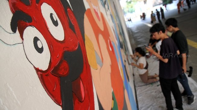 Sejumlah mahasiswa menyelesaikan pembuatan mural di terowongan Kendal, Dukuh Atas, Jakarta, Kamis (20/6). [Suara.com/Arief Hermawan P]