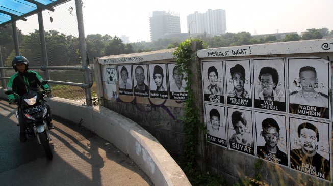 Warga melintas diantara poster para aktivis yang hilang yang tertempel di kawasan Beji, Kota Depok, Jawa Barat, Sabtu (22/6). [Suara.com/Arief Hermawan P]