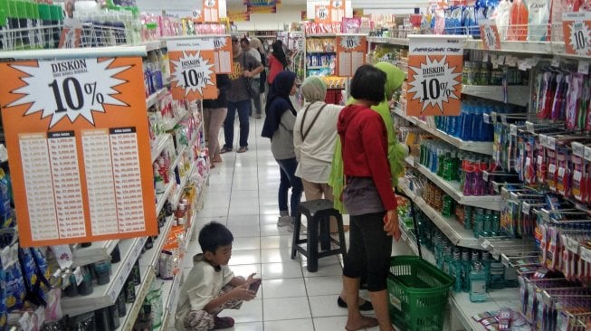 Warga berbelanja di gerai Giant Ekspres Mampang Prapatan, Minggu (23/6). [Suara.com/Muhaimin A Untung]