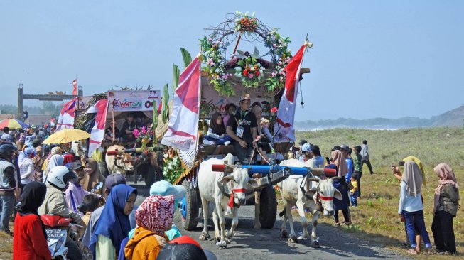 Warga menyaksikan Festival Pegon "Watu Ulo Pegon (Waton) Parade 2019" di Desa Sumberejo, Ambulu, Jember, Jawa Timur, Minggu (23/6). ANTARA FOTO/Seno