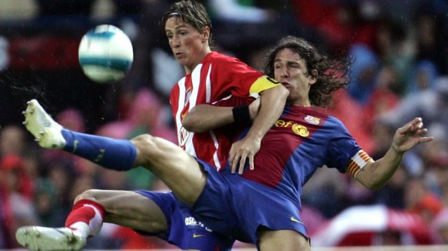 Momen ketika Fernando Torres berduel dengan Carles Puyol. (Bru Garcia/AFP).