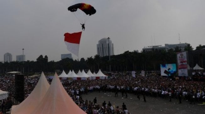 Anggota Polisi melakukan terjun payung dalam Festival Damai dan Millennial Safety Road di Monas, Jakarta Pusat, Minggu (23/6/2019). Kegiatan tersebut diadakan Polda Metro Jaya untuk merajut persatuan dan kesatuan dalam kebhinekaan serta sekaligus sosialisasi disiplin dalam berlalu lintas khususnya bagi generasi milenial [ANTARA FOTO/Sigid Kurniawan/ama]