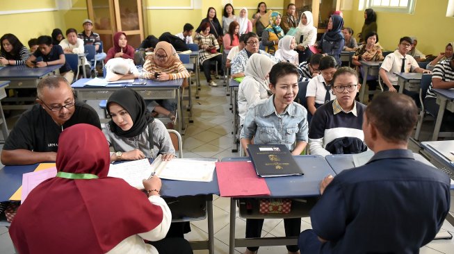 Sejumlah siswa dan orang tua murid mendaftar seleksi Penerimaan Peserta Didik Baru (PPDB) menggunakan komputer di SMAN 1 Jakarta, Jakarta, Senin (24/6). ANTARA FOTO/Galih Pradipta