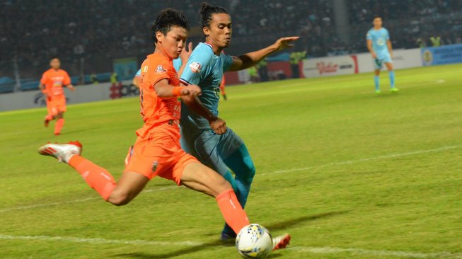 Pemain Persija Jakarta Feby Eka Putra (kiri) berusaha melewati pemain Persela Lamongan Samsul Arifin (kanan) dalam pertandingan Liga 1 2019 di Stadion Surajaya Lamongan, Jawa Timur, Sabtu (22/6/2019). Persela Lamongan tahan imbang Persija Jakarta dengan skor 0-0. ANTARA FOTO/Syaiful Arif.