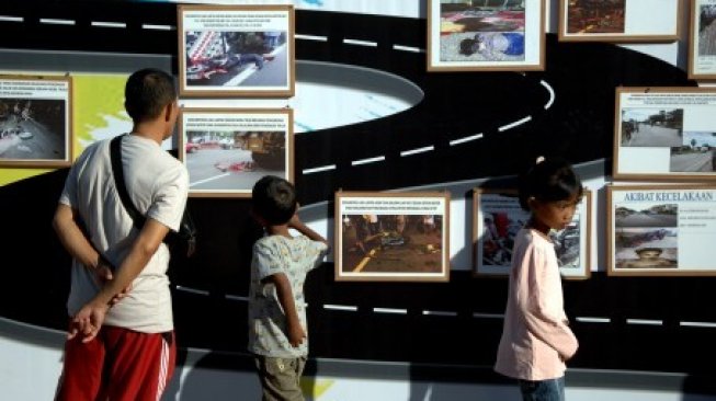 Warga memperhatikan pameran kecelakaan lalu lintas (Lakalantas) pada Millenial Road Safety Festival di Makassar, Sulawesi Selatan, Minggu (23/6/2019). Kegiatan yang dilaksanakan Polda Sulsel ini untuk mensosialisasikan kedisiplinan dalam berlalu lintas kepada generasi milenial dan sebagai gerakan moral untuk menekan angka kecelakaan lalu lintas [ANTARA FOTO/Abriawan Abhe]