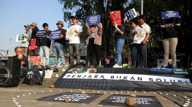 Sejumlah aktivis yang berasal dari organisasi Lembaga Bantuan Hukum Masyarakat (LBHM) menggelar aksi di kawasan Monas, Jakarta, Selasa (25/6). [Suara.com/Arief Hermawan P]