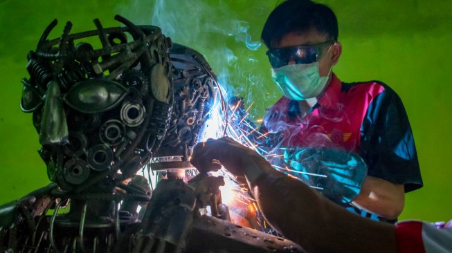 Siswa menyelesaikan pembuatan robot polisi berbahan onderdil motor bekas di SMK Karya Utama, Warung Bambu, Karawang, Jawa Barat, Senin (24/6). ANTARA FOTO/M Ibnu Chazar