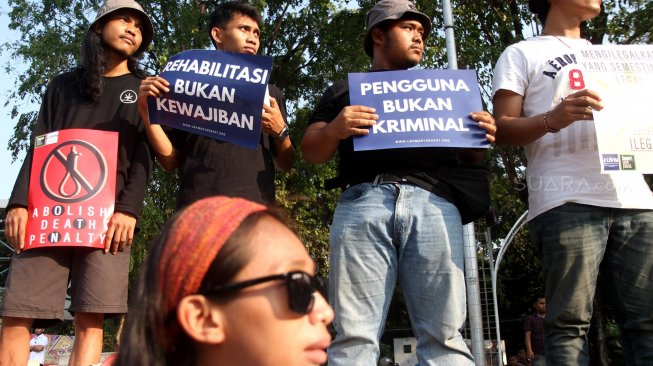 Sejumlah aktivis yang berasal dari organisasi Lembaga Bantuan Hukum Masyarakat (LBHM) menggelar aksi di kawasan Monas, Jakarta, Selasa (25/6). [Suara.com/Arief Hermawan P]