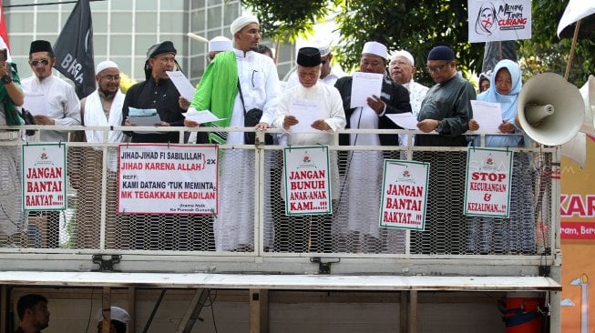 Sejumlah massa yang berasal dari Persaudaraan Alumni (PA) 212 berunjuk rasa di sekitar Patung Kuda, Monas, Rabu (26/6). Dalam aksi yang berlangsung damai tersebut, mereka meminta Mahkamah Konstitusi (MK) memberikan keputusan seadil-adilnya dalam sidang sengketa perselisihan hasil pemilihan umum (PHPU) yang akan digelar Kamis (27/6). [Suara.com/Arief Hermawan P]