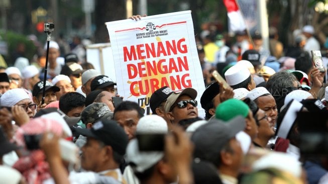 Sejumlah massa yang berasal dari Persaudaraan Alumni (PA) 212 berunjuk rasa di sekitar Patung Kuda, Monas, Rabu (26/6). Dalam aksi yang berlangsung damai tersebut, mereka meminta Mahkamah Konstitusi (MK) memberikan keputusan seadil-adilnya dalam sidang sengketa perselisihan hasil pemilihan umum (PHPU) yang akan digelar Kamis (27/6). [Suara.com/Arief Hermawan P]