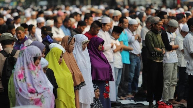 Sejumlah peserta aksi melakukan salat Ashar berjamaah di kawasan Gedung Mahkamah Konstitusi, Jakarta, Kamis (27/6). [Suara.com/Muhaimin A Untung]
