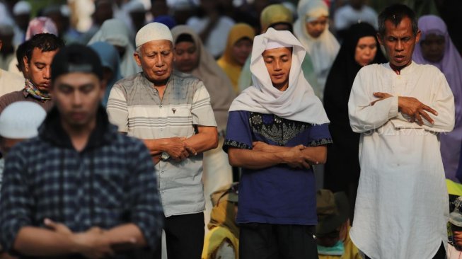 Sejumlah peserta aksi melakukan salat Ashar berjamaah di kawasan Gedung Mahkamah Konstitusi, Jakarta, Kamis (27/6). [Suara.com/Muhaimin A Untung]
