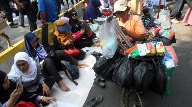 Sejumlah pedagang berjualan diantara massa yang berkumpul di kawasan Patung Kuda, Monas, Jakarta, Kamis (27/6). [Suara.com/Arief Hermawan P]