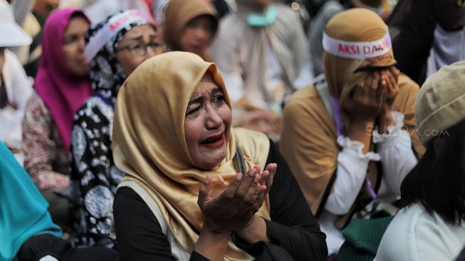 Emak-emak peserta aksi menangis saat mengikuti aksi di kawasan Mahkamah Konstitusi, Jakarta, Kamis (27/6). [Suara.com/Muhaimin A Untung]