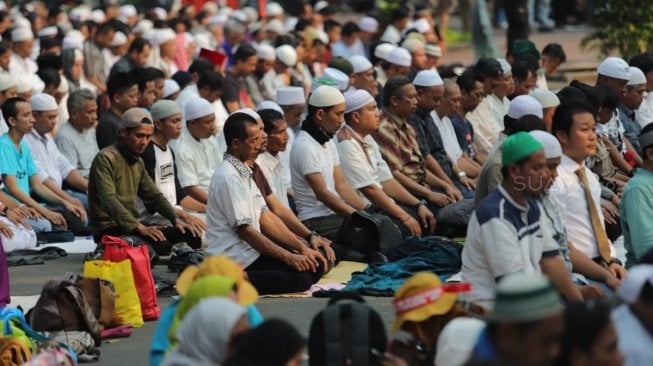 Sejumlah peserta aksi melakukan salat Ashar berjamaah di kawasan Gedung Mahkamah Konstitusi, Jakarta, Kamis (27/6). [Suara.com/Muhaimin A Untung]
