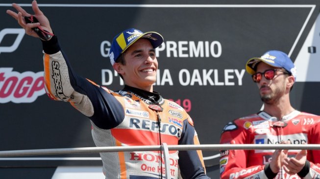 Pebalap Repsol Honda, Marc Marquez (kiri), dan rider Ducati, Andrea Dovizioso, merayakan keberhasilan meraih podium kedua dan ketiga MotoGP Italia di Sirkuit Mugello, Minggu (2/6/2019). [AFP/Tiziana Fabi]