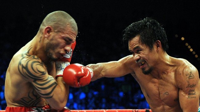 Petinju Filipina, Manny Pacquiao (kanan), mendaratkan pukulan telak ke wajah Miguel Cotto dalam duel kejuaraan dunia tinju kelas welter WBO di MGM Grand Garden Arena, Las Vegas, AS, Sabtu (14/11/2009). [AFP/Gabriel Bouys]