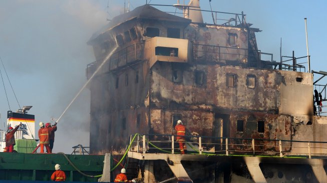 Petugas memadamkan kapal KM Persada X yang terbakar di salah satu dok kapal, di Pelabuhan Tanjung Perak, Jalan Nilam Barat no 14 Surabaya, Jawa Timur, Sabtu (29/6).  [ANTARA FOTO/Didik Suhartono]