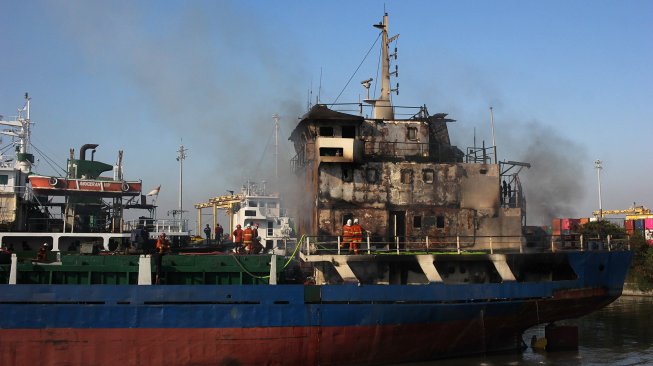 Petugas memadamkan kapal KM Persada X yang terbakar di salah satu dok kapal, di Jalan Nilam Barat no 14 Surabaya, Jawa Timur, Sabtu (29/6).  [ANTARA FOTO/Didik Suhartono]