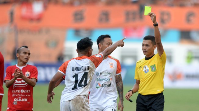 Wasit Wawan Rapiko (kanan) memberikan kartu kuning pada pesepak bola Borneo FC Abrizal Umanailo (ketiga kanan) saat melawan Persija Jakarta dalam pertandingan semifinal leg pertama Piala Indonesia di Stadion Wibawa Mukti, Cikarang, Kabupaten Bekasi, Jawa Barat, Sabtu (29/6/2019). Persija Jakarta menang dengan skor 2-1. ANTARA FOTO/M Risyal Hidayat