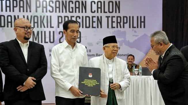 Ketua KPU Arief Budiman beserta komisioner KPU menyerahkan surat keputusan KPU tentang Penetapan Hasil Pemilu 2019 kepada Presiden dan Wakil Presiden terpilih periode 2019-2024, Joko Widodo dan KH Ma'ruf Amin di gedung KPU, Jakarta, Minggu (30/6). [Suara.com/Muhaimin A Untung]