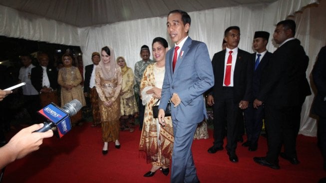 Presiden Joko Widodo didampingi Ibu Negara Iriana Joko Widodo menyapa wartawan saat menghadiri pesta pernikahan putri pertama Gubernur Jawa Timur Khofifah Indar Parawansa, Patimasang dengan Fadil Wirawan di Surabaya, Jawa Timur, Sabtu (29/6). ANTARA FOTO/Moch Asim