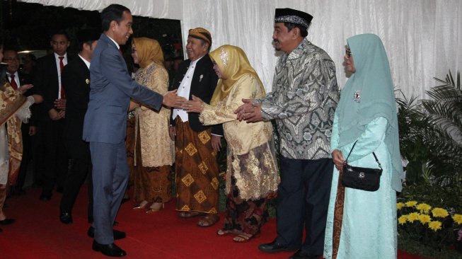 Presiden Joko Widodo (kiri) bersalaman dengan penerima tamu saat menghadiri pesta pernikahan putri pertama Gubernur Jawa Timur Khofifah Indar Parawansa, Patimasang dengan Fadil Wirawan di Surabaya, Jawa Timur, Sabtu (29/6). ANTARA FOTO/Moch Asim