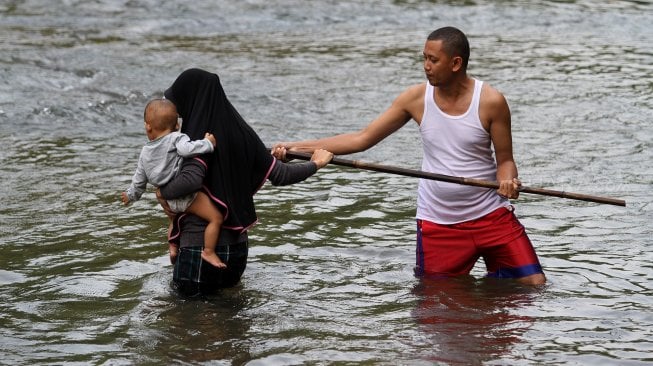 Sejumlah warga menikmati suasana sungai Ciliwung di kawasan Depok, Jawa Barat, Senin (1/7). [Suara.com/Arief Hermawan P]