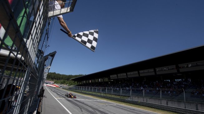 Pebalap Red Bull Racing, Max Verstappen, melintasi garis finis pertama pada balapan seri kesembilan F1 GP Austria di Sirkuit Red Bull Racing, Minggu (30/6/2019). [AFP/Andrej Isakovic]