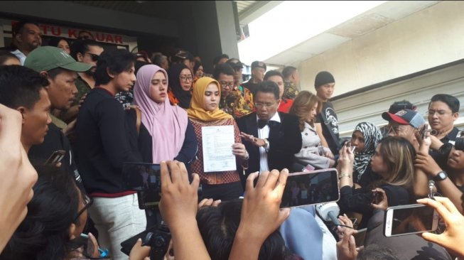 Fairuz A Rafiq didampingi suami (Sonny Septian), kakak (Ranny Fahd A Rafif), dan kuasa hukumnya (Hotman Paris) di Polda Metro Jaya, Senin (1/7/2019). [Yuliani/Suara.com]