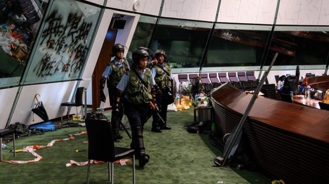 Polisi menyisir gedung parlemen Hong Kong usai aksi massa pada Senin (1/7/2019) malam waktu setempat. (AFP)