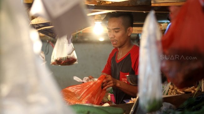 Pedagang melayani pembeli di Pasar Senen, Jakarta, Rabu (3/7). [Suara.com/Arief Hermawan P]