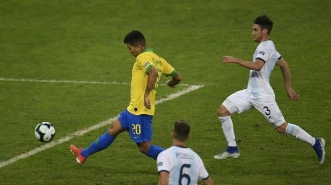 Pemain depan Brasil Roberto Firmino mencetak gol ke gawang Argentina di semifinal Copa America 2019. MAURO PIMENTEL / AFP