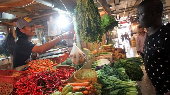 Pedagang melayani pembeli di Pasar Senen, Jakarta, Rabu (3/7). [Suara.com/Arief Hermawan P]