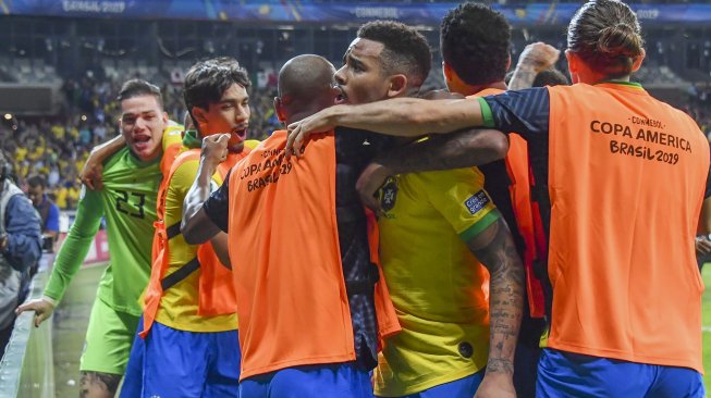 Penyerang Brasil Gabriel Jesus merayakan gol setelah rekan setimnya Roberto Firmino mencetak gol saat melawan Argentina selama pertandingan semifinal Copa America di Stadion Estadio Mineirao, Brasil, Rabu (3/7). [Nelson ALMEIDA / AFP]