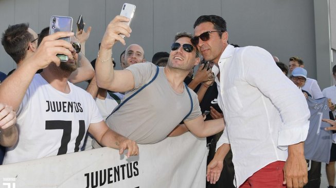 Gianluigi Buffon (kanan) melakukan swafoto dengan tifosi Juventus di J Medical, Turin, Kamis (4/7/2019) WIB. [Laman resmi Juventus]