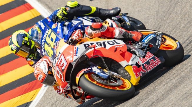 Pebalap Repsol Honda, Marc Marquez, berada di depan rider Yamaha, Valentino Rossi, pada balapan MotoGP Jerman di Sirkuit Sachsenring, Minggu (15/7/2018). [AFP/Robert Michael]