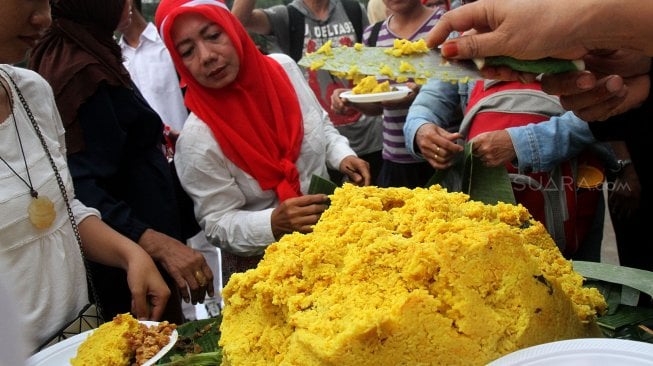 Sejumlah pendukung Presiden Terpilih Joko Widodo-Ma'ruf Amin yang tergabung dalam Relawan Indonesia Bersatu menggelar acara tumpengan di depan Istana Merdeka, Jakarta, Jumat (5/7). [Suara.com/Arief Hermawan P]