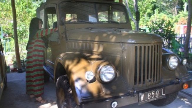 Pengunjung melihat koleksi mobil kuno yang dipajang di Museum Kampung Cak Soen, Ngawi, Jawa Timur, Sabtu (6/7/2019). Museum mobil kuno yang didirikan di tengah perkampungan ini ramai dikunjungi wisatawan terutama saat liburan sekolah [ANTARA FOTO/Ari Bowo Sucipto/foc].