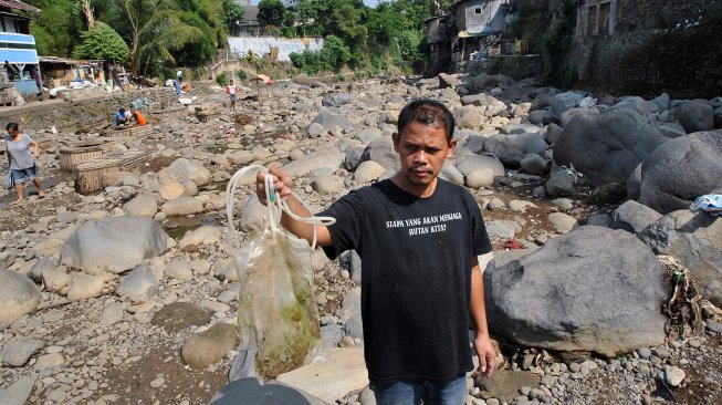 Warga menunjukkan limbah medis saat Mulung Sampah di sungai Ciliwung, Kampung Kebon Jukut, Kelurahan Babakan Pasar, Kota Bogor, Jawa Barat, Sabtu (6/7). [ANTARA FOTO/Arif Firmansyah]