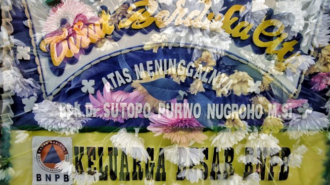 Sejumlah karangan bunga berdatangan ke rumah duka almarhum Sutopo Purwo Nugroho di kediamannya, Rafles Hills, Cimanggis, Depok, Minggu (7/7). [Suara.com/Muhaimin A Untung]
