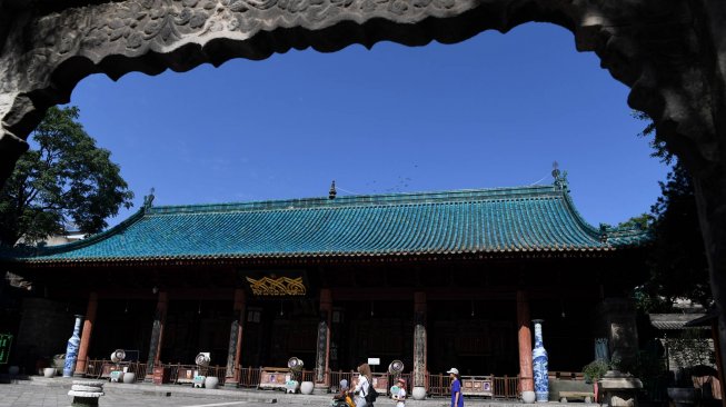 Seorang petugas masjid melintas di samping gerbang Masjid Raya Xi'an di Xi'an, Shaanxi, China, Sabtu (6/7). ANTARA FOTO/Zabur Karuru