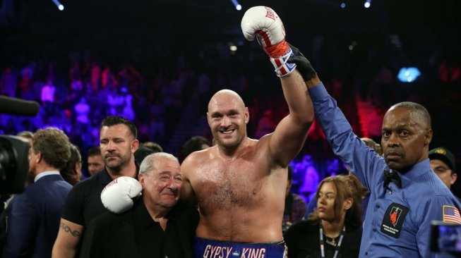 Petinju kelas berat asal Inggris, Tyson Fury (tengah), merayakan keberhasilannya memenangi duel melawan Tom Schwarz, Sabtu (15/6/2019), di MGM Grand Garden Arena, Las Vegas, AS. [AFP/Steve Marcus]