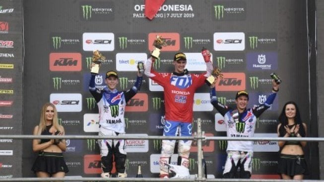 Crosser HRC Team Tim Gajser (tengah) bersama dua crosser Monster Energy Yamaha Factory MXGP Team Romain Febvre (kedua kiri) dan Jeremy Seewer (kedua kanan) menunjukan trofi di podium usai balapan seri Palembang kejuaraan dunia Motocross Grand Prix MXGP 2019 di Sirkuit OPI Mall, Palembang, Sumatera Selatan, Minggu (7/7/2019). Pembalap HRC Team Tim Gajser menjuarai MXGP 2019 seri Palembang setelah mengumpulkan 47 poin dalam dua sesi balapan [ANTARA FOTO/Hafidz Mubarak A/aww].