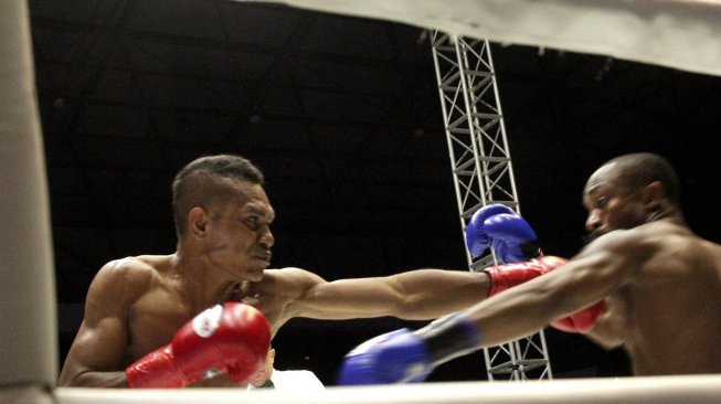 Petinju Indonesia Tibo Monabesa (kiri) melancarkan pukulan ke arah lawannya petinju Australia Omari Kimweri dalam laga "The Border Battle" di GOR Oepoi, Kupang, NTT, Minggu (7/7/2019). [Antara/Kornelis Kaha]