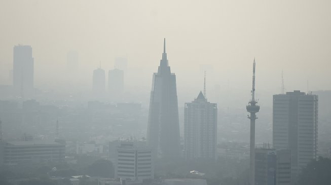 Gedung bertingkat tersamar kabut polusi udara di Jakarta, Senin (8/7). [ANTARA FOTO/M Risyal Hidayat]