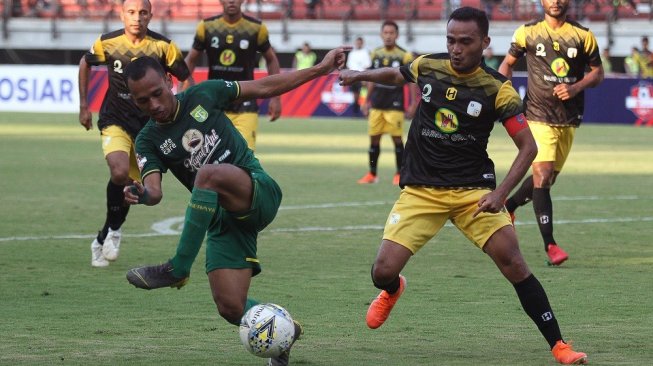 Pesepak bola Persebaya Irfan Jaya (kiri) mencoba melewati hadangan pesepak bola PS Barito Putera Rizky Rizaldi Pora (kanan) saat pertandingan Liga 1 2019 di Stadion Gelora Bung Tomo, Surabaya, Jawa Timur, Selasa (9/7/2019). Persebaya ditahan imbang PS Barito Putera dengan skor akhir 2-2. ANTARA FOTO/Moch Asim