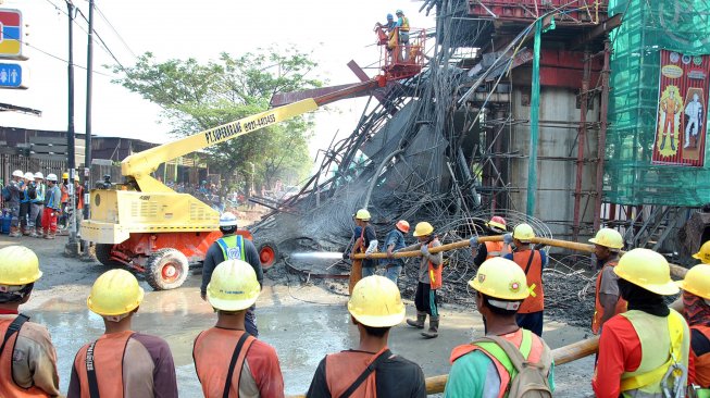 Sejumlah pekerja membersihkan material coran semen di lokasi ambruknya salah satu tiang penyangga proyek pembangunan Tol Bogor Outer Ring Road (BORR) Seksi IIIA simpang Yasmin-Semplak di jalan raya KH Sholeh Iskandar, Kelurahan Cibadak, Tanah Sareal, Kota Bogor, Jawa Barat, Rabu (10/7). [ANTARA FOTO/Arif Firmansyah]