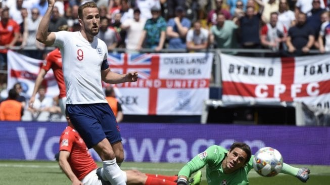 Penyerang Timnas Inggris, Harry Kane mencetak gol ke gawang Swiss pada laga UEFA  Nations League 2019 di Stadion Afonso Henriques, Guimaraes, Portugal, 9 Juni 2019. (MIGUEL RIOPA / AFP)