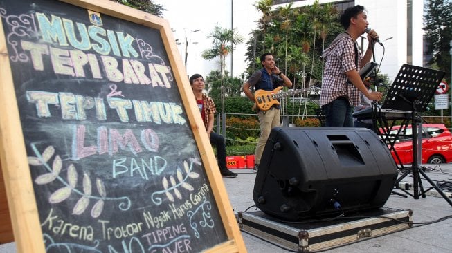 Sejumlah seniman tampil membawakan musik untuk menghibur warga yang melintas di area Taman Spot Budaya, Dukuh Atas, Jakarta, Jumat (12/7). [Suara.com/Arief Hermawan P]